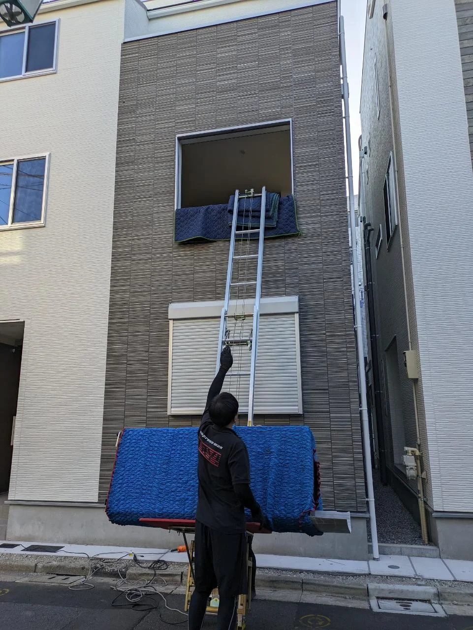 大型家電を二人で安全に運び入れ設置位置を確認する作業者