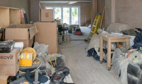 An interior filled with belongings and materials before items are carried out
