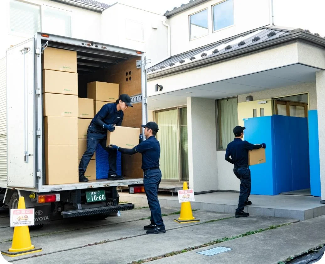 Workers passing boxes from a moving truck into a home